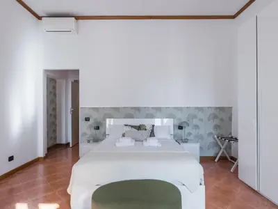 a bedroom with a large white bed with a green rug at The Best Rent - Three-bedroom apartment near Piazza Barberini in Rome