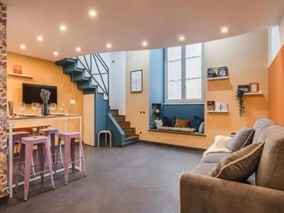 a living room with a couch and a table and a staircase at The Best Rent - Colorful loft in Trastevere area in Rome