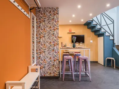 a room with a bar with stools and a wall at The Best Rent - Colorful loft in Trastevere area in Rome