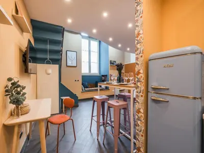 a kitchen with a refrigerator and some stools at The Best Rent - Colorful loft in Trastevere area in Rome