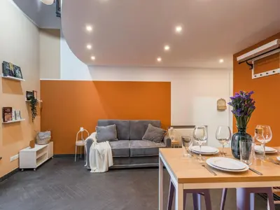 a living room with a couch and a table with wine glasses at The Best Rent - Colorful loft in Trastevere area in Rome