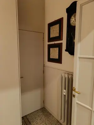 a hallway with a door and a clock on the wall at Gay House Roma - Only Gay in Rome