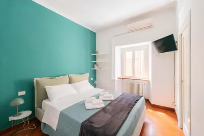 a bedroom with a bed with a blue wall at AppleMoon2.0 in Rome