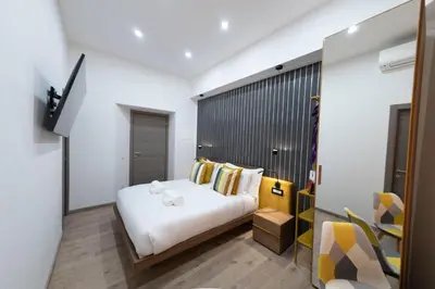 a bedroom with a white bed in a room at Cola Suites Apartments in Rome