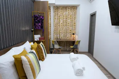 a bedroom with a bed with yellow and white pillows at Cola Suites Apartments in Rome