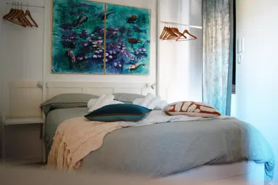 a bedroom with a bed with a painting on the wall at Grottino 3a Apartment in Rome