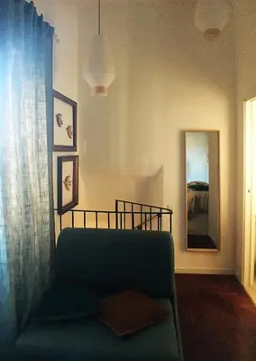 a living room with a green couch and a mirror at Grottino 3a Apartment in Rome