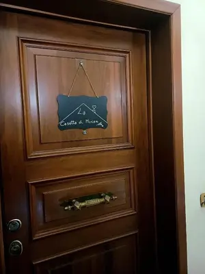 a wooden door with a sign on it at La Casetta di Miriam a Piazza di Spagna in Rome