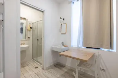 a white bathroom with a sink and a shower at Vatican Momahouse Luxury by Varental in Rome