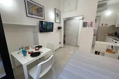 a kitchen with a white table and a white table and a room at Pigneto Easy Stay in Rome