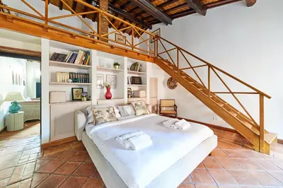 a bedroom with a white bed and a staircase at iFlat Shabby Chic Apartament in Rome