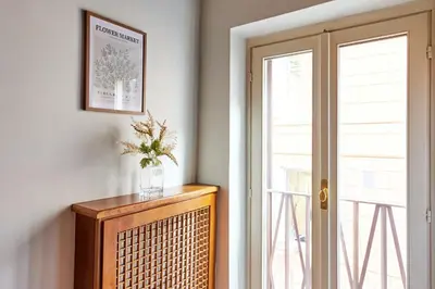 a vase of flowers on top of a dresser next to a window at iFlat Shabby Chic Apartament in Rome