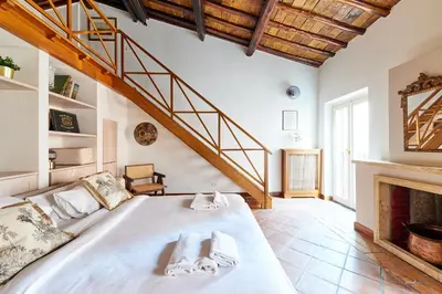 a bedroom with a large bed and a staircase at iFlat Shabby Chic Apartament in Rome