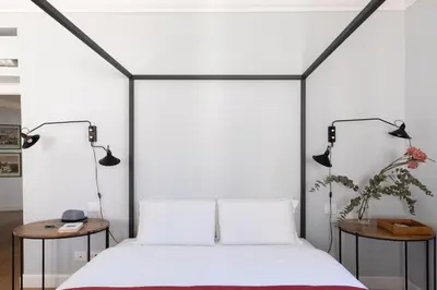 a bedroom with a white bed with two side tables at iFlat Bright and Modern Flat near the Pantheon in Rome