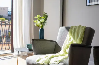 a vase of flowers in a room with a chair at iFlat Bright and Modern Flat near the Pantheon in Rome