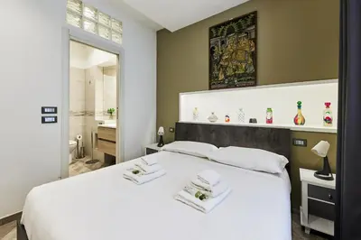 a bedroom with a white bed and a bathroom at iFlat One step from Colosseum in Rome