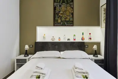 a bedroom with a large white bed with towels on it at iFlat One step from Colosseum in Rome