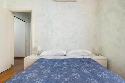 a bedroom with a large bed with a blue blanket at Comfortable apartment Via Appia - B in Rome