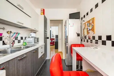 a kitchen with a counter and red chairs in it at Comfortable apartment Via Appia - B in Rome