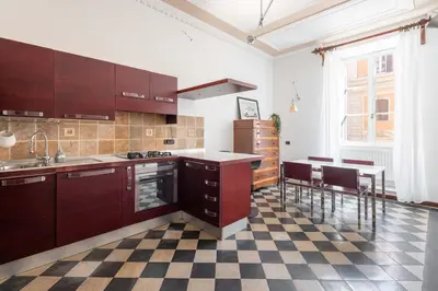 a kitchen with wooden cabinets and a checkered floor at Maison Leo a S. Maria Maggiore in Rome