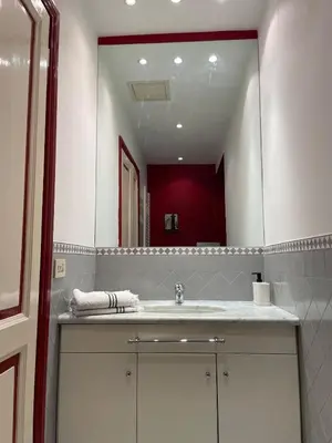 a bathroom with a sink and a large mirror at Lilla’s Apartment in Rome