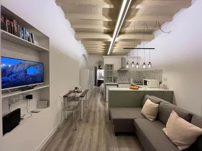 a living room with a couch and a kitchen at Beloved Trastevere in Rome
