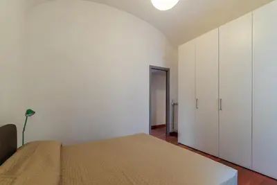 a bedroom with a bed and a white wall at GuestHost - San Giovanni in Laterano Dazzling Apartment in Rome