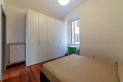 a white bedroom with a bed and a window at GuestHost - San Giovanni in Laterano Dazzling Apartment in Rome