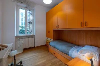a bedroom with orange cabinets and a bed and a desk at Domus Villa Scipioni in Rome