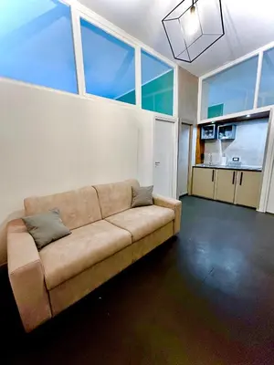 a living room with a couch in a room with large windows at JEF Apartments San Giovanni by Hostand in Rome