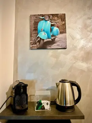 a blue scooter hanging on a wall next to a kettle at JEF Apartments San Giovanni by Hostand in Rome