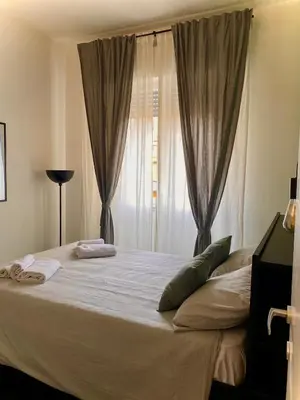 a bedroom with a large bed with a window at JEF Apartments San Giovanni by Hostand in Rome
