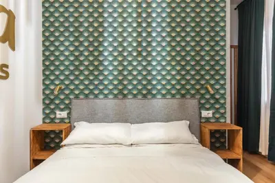 a bedroom with a large bed and a wall with at Koba Rooms Nomentano in Rome