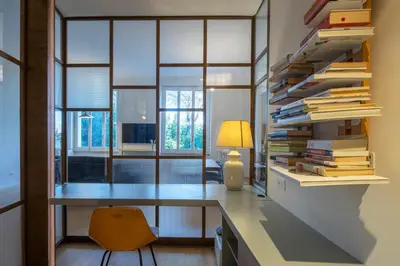 a room with a desk with a stack of books at Luna's Apartment BuddyRent in Rome