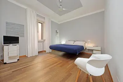 a white bedroom with a bed and a tv at Piscinula in Rome