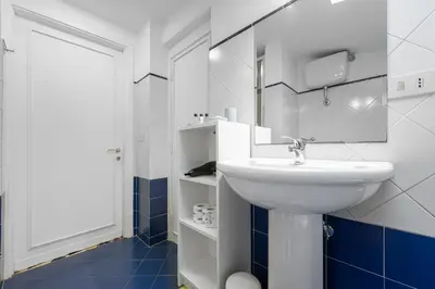 a white bathroom with a sink and a mirror at Flaminio Charme Apartment in Rome