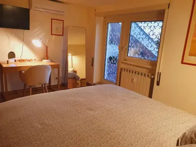 a bedroom with a bed and a desk and a window at Appartamento 