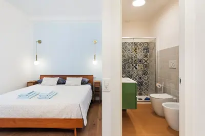 a bedroom with a bed and a bathroom with a tub at Supreme Apartments Vaticano in Rome