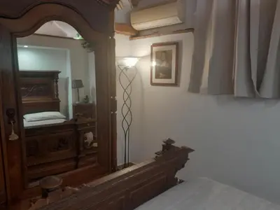 a bedroom with a mirror and a lamp next to a bed at DOMUS GELSOMINO in Rome