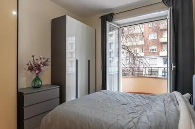 a bedroom with a bed and a large window at GuestHost - Piazzale delle Provincie Apartment in Rome