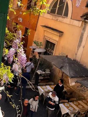 a group of people standing around a restaurant with an umbrella at Anna’s home in Rome