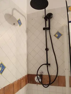 a shower with a black shower head in a bathroom at Anna’s home in Rome