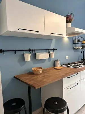 a kitchen with white cabinets and a wooden counter top at La Casa di Testaccio Apartment in Rome