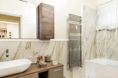 a white bathroom with a sink and a mirror at Menotti elegant apartment in Rome