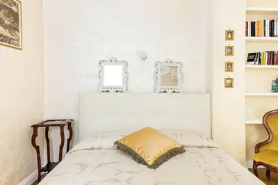 a bedroom with a bed with a yellow pillow on it at Menotti elegant apartment in Rome