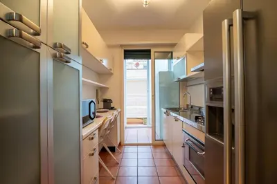a kitchen with white cabinets and a tile floor at ArtStay - Luxury Penthouse Metro B, Tiburtina in Rome