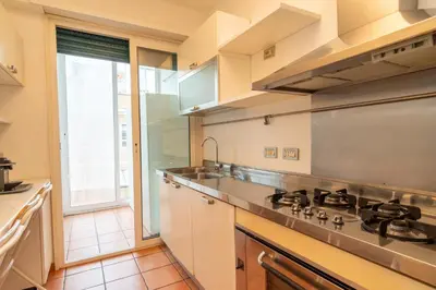 a kitchen with a stove and a large window at ArtStay - Luxury Penthouse Metro B, Tiburtina in Rome