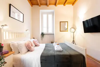 a bedroom with a large white bed with pink pillows at Orso 70 apartment in Rome
