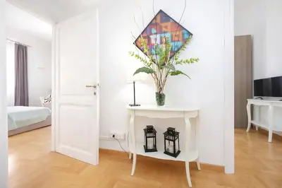 a room with a table with a vase of flowers on it at Luxury Apartment for 10 Central VATICANO S'Peter Basilica AirCond NETFLIX - SKY Wifi in Rome
