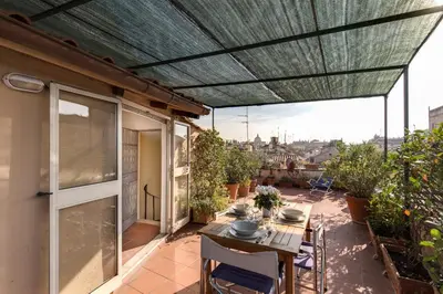 a patio with a table and chairs and awning at Amazing penthouse with terrace near Navona Square in Rome